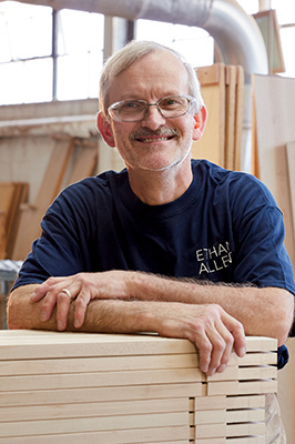 smiling employee with unfinished wood