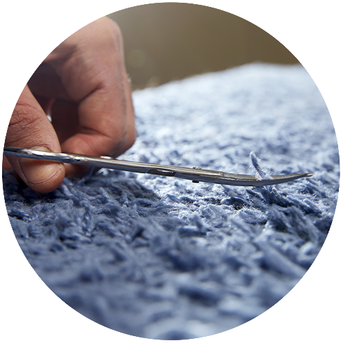 rug being trimmed with scissors