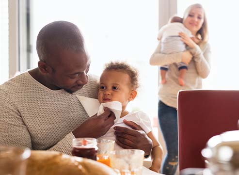 young couple eating breakfast with children